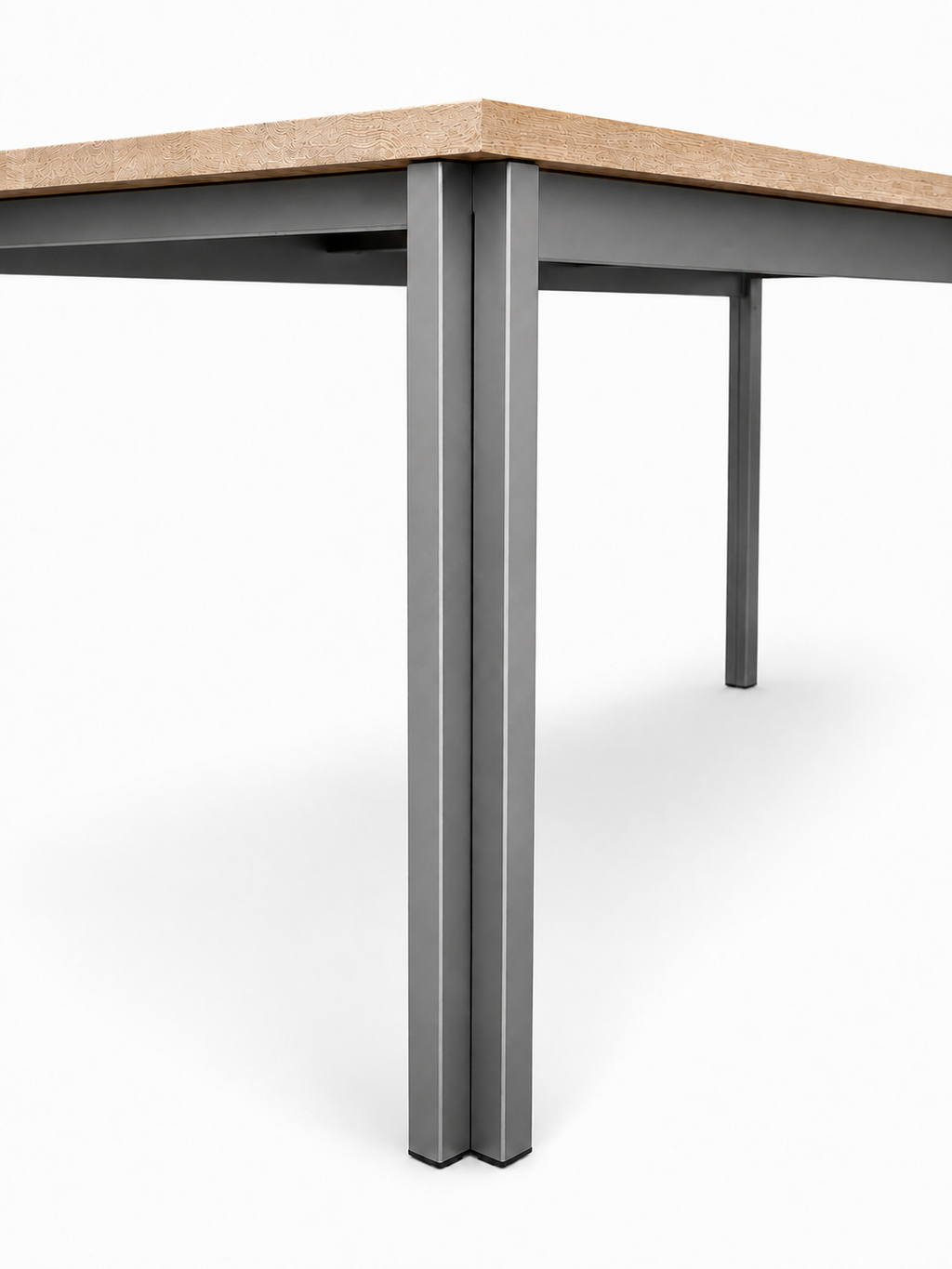 Detalje af spisebordets ben og stel i rustfrit stål med bordplade i massivt egetræ.